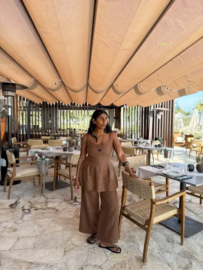 An image of @monikh wearing a waisted top from Faithfull The Brand, one of the key summer tops trends of 2025.