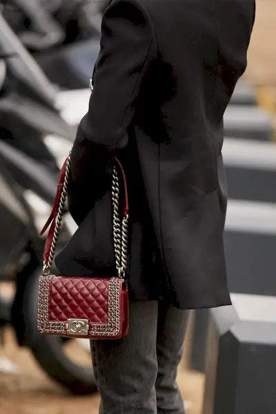 most popular chanel bags shown in a street style photo of a woman carrying a chanel boy bag