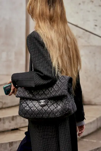 most popular chanel bags shown in a street style photo of a woman carrying a chanel bag