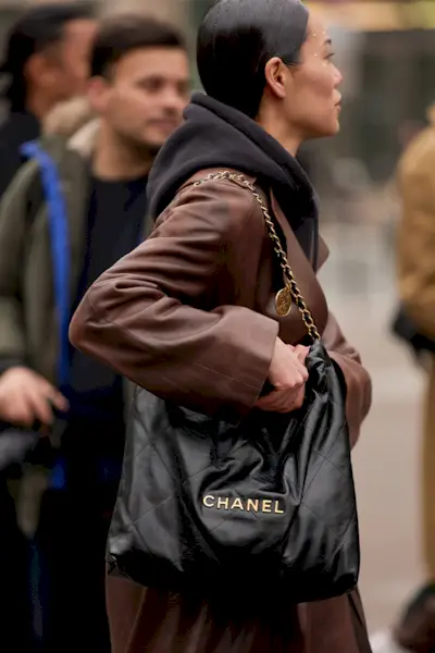 most popular chanel bags shown in a street style photo of a woman carrying a chanel tote bag