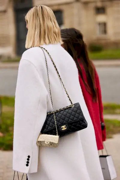 most popular chanel bags shown in a street style photo of a woman carrying a chanel flap bag