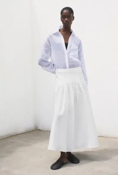 @anoukyve wearing white trousers and a shirt