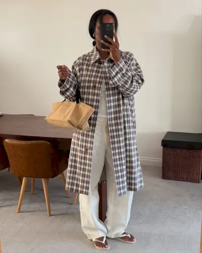 Marilyn wears a plaid jacket, white jeans, white flip-flops, and a brown bag.