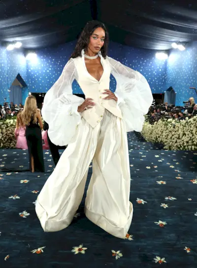 Laura Harrier wears a pair of cream satin trousers at the Met Gala 2025