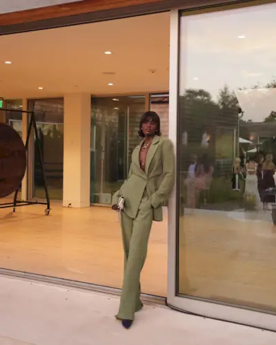 fitted blazer trend is shown on a woman wearing a green blazer with matching trousers and pointed heels