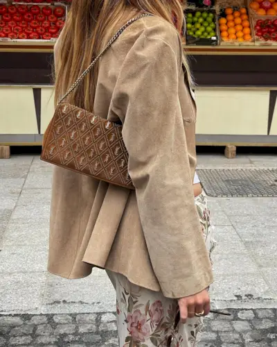 Woman wearing fall brown suede bag trend.