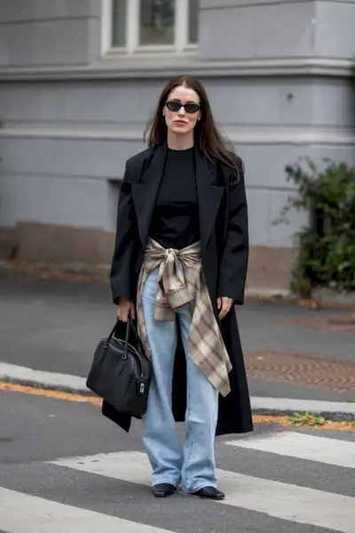 An image of Annabel Rosendahl wearing wide-leg jeans with a blazer and a flannel shirt.