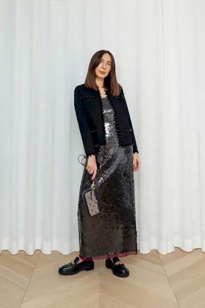 a casual party outfit shown on a woman standing wearing a sequin maxi dress with a black blazer and black loafers