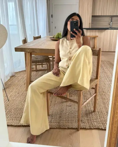 @monikh wears a linen suit vest and matching wide-leg trousers in a butter yellow.