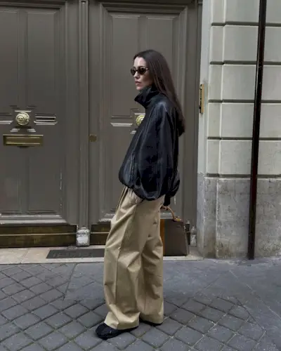 Annabel wears a leather jacket, sneakers, and chinos.