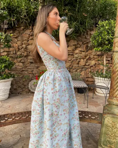 a photo showing cocktail attire for women with a woman wearing a floral dress