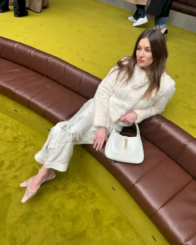 a photo showing cocktail attire for women with a woman wearing white trousers and a white faux fur and white slingback heels