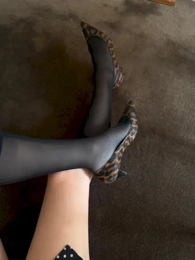 Christie wears leopard pumps with sheer black socks.