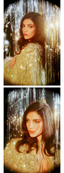 Ella Rubin stands in front of a silver tinsel backdrop wearing a floor-length mint green Valentino gown with jewel embellishments and furry detailing at the hemline and a matching capelet.