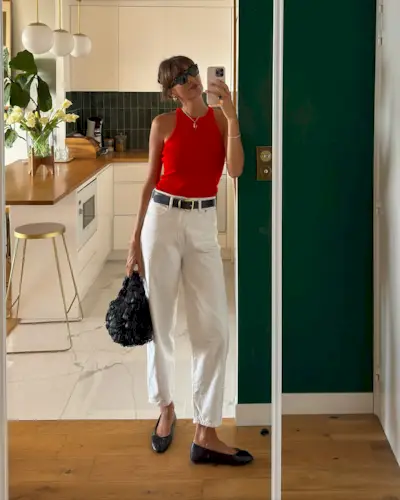 French influencer wearing a red tank and cream jeans