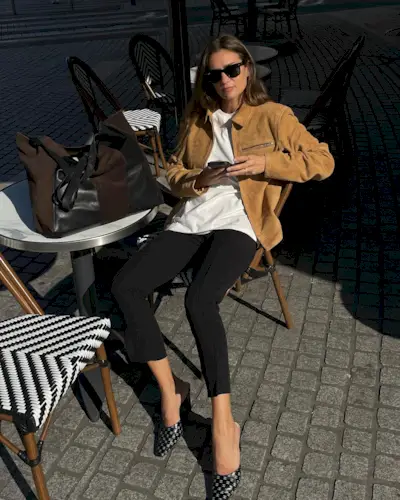 French fashion influencer Anne-Laure Mais wearing a chic fall outfit with black pants in Paris.