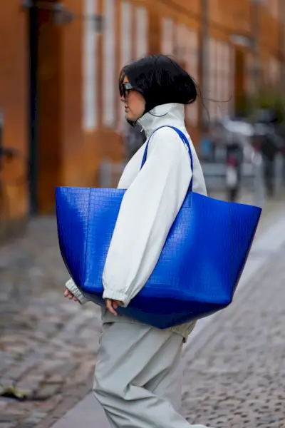 Woman wearing cobalt blue bag during Copenhagen Fashion Week.