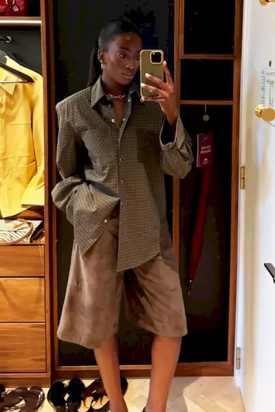 A woman wearing a plaid shirt and tan shorts