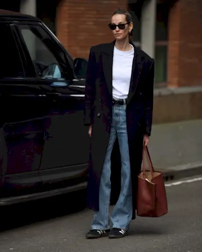 woman wearing flare jeans and black long coat