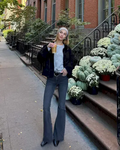 woman wearing flare jeans and belt with black jacket