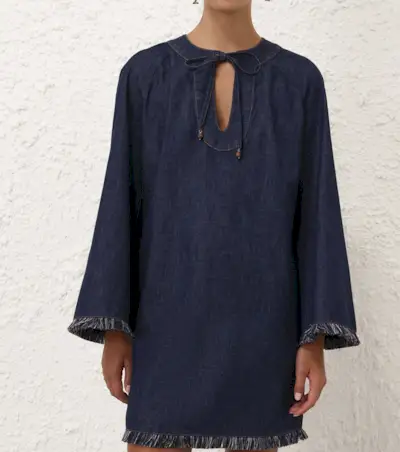 Celeberity Rochelle Humes wears the denim dress trend. She is wearing a sold out ASOS design dress with black wedge kitten heels. She is stood outside the BBC's brown brick wals looking away from the camera in a recent image taken from her Instagram.