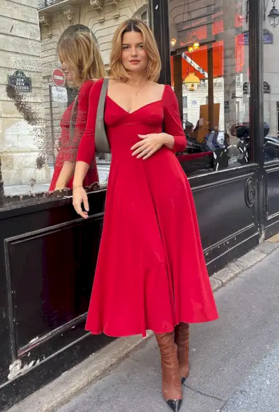a photo of a woman wearing a red dress with brown knee high boots