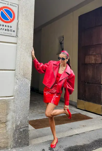 a photo of a woman wearing a red dress with red ballet flats and a matching leather jacket, what shoes to wear with a red dress