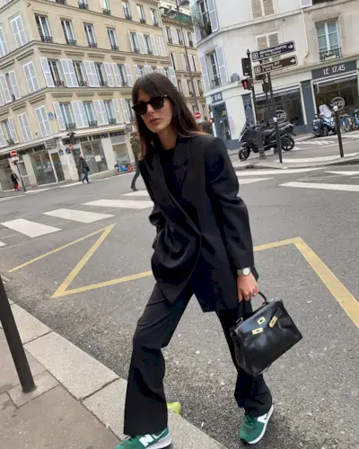 woman in a black suit and sneakers