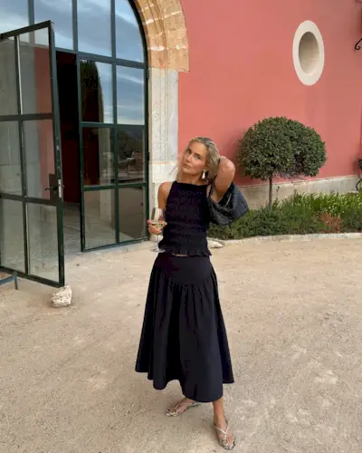 Woman wearing black maxi skirt and matching top.