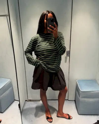 @nlmarilyn wearing a green striped Miu Miu T-shirt with Bermuda shorts and flat sandals.
