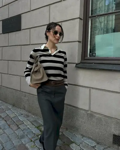 @annabelrosendahl wearing a striped rugby sweater with trousers.