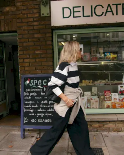 @lucywilliams02 wearing a striped rugby shirt with a tan sweater and trousers.