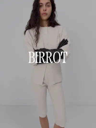 A photo of a model wearing a cream sweater and pedal pushers set. Text says 'Birrot in white capital serif letters.