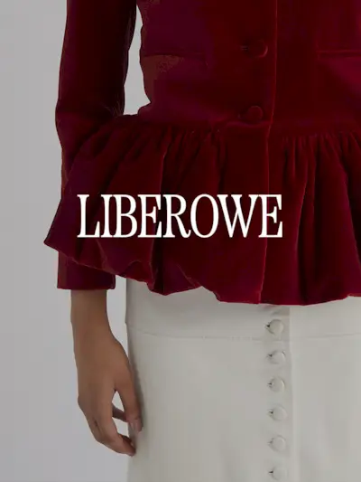 A photo of a model wearing a red velvet peplum jacket and leather skirt. Text says 'Liberowe in white capital serif letters.