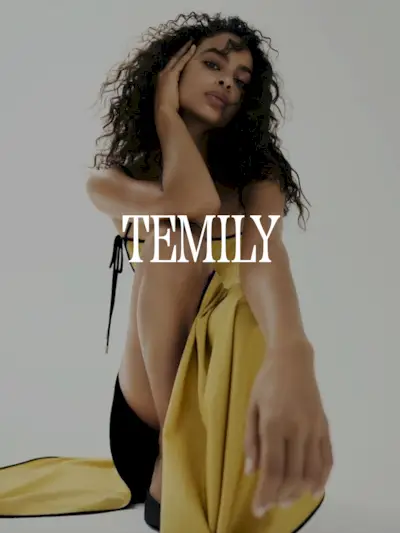 A photo of a model wearing a Temily mustard colored dress. Text says 'Temily in white capital serif letters.