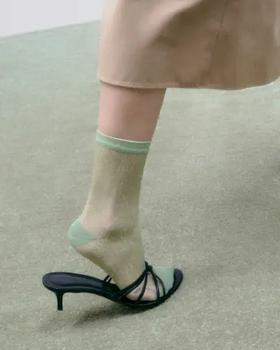 Model wearing green sheer sock and black Le Monde Beryl shoe.