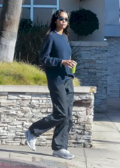 Laura Harrier wears cream trainers.