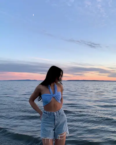 a photo of a woman's beach outfit with blue sarong bikini top and denim shorts