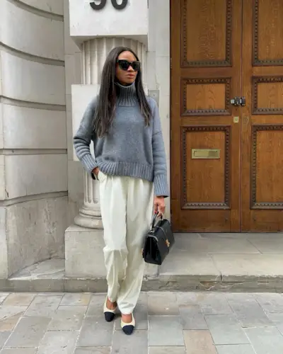 @symphonyofsilk wears a pair of cream satin trousers with a gray jumper