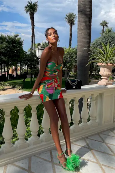 a photo of a club outfit with a woman wearing silk printed skirt set and green statement heels