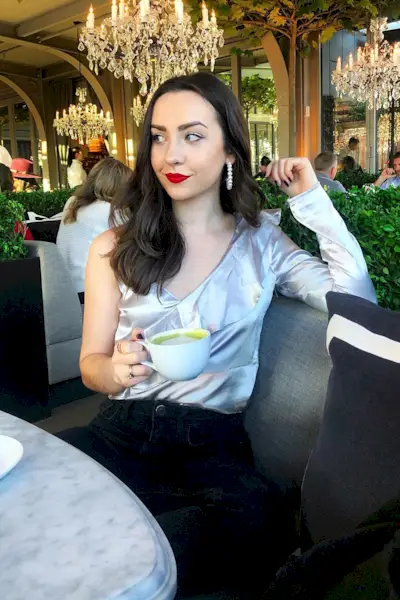 outfits to wear on a first date shown on a woman wearing earrings, a deep v-neck silver top, and black pants