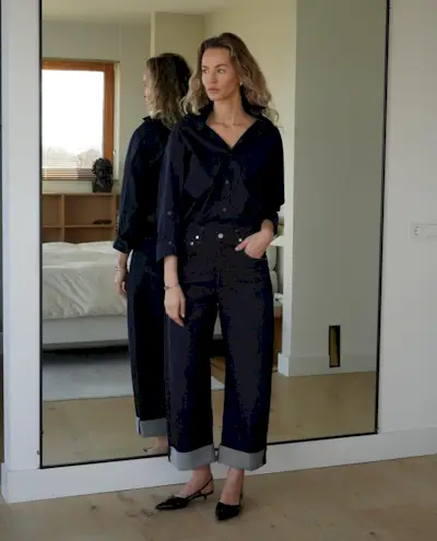 Woman wearing a stylish outfit with cuffed jeans.