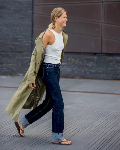 Woman wearing a stylish outfit with cuffed jeans.