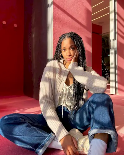 Woman wearing a stylish outfit with cuffed jeans.