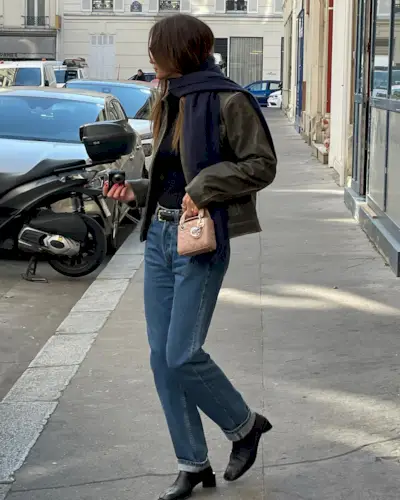Woman wearing a stylish outfit with cuffed jeans.