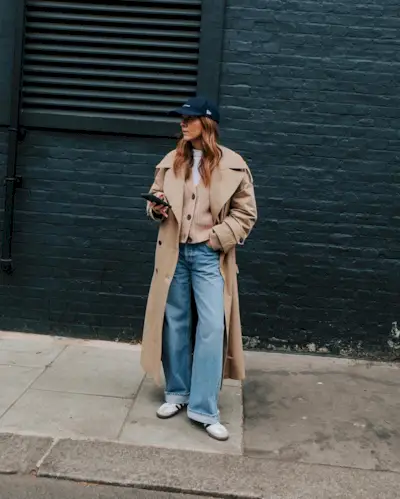 Woman wearing a stylish outfit with cuffed jeans.