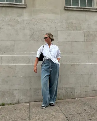 Woman wearing a stylish outfit with cuffed jeans.