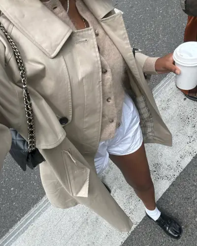 woman wearing white boxer shorts and loafers with trench coat