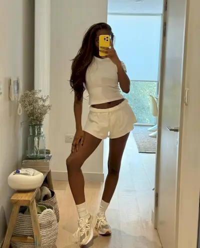 woman wearing white sweat shorts with white t-shirt and sneakers