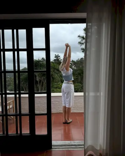 woman wearing long white trousers and belt with cropped white top